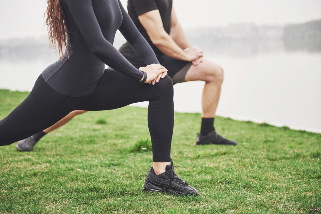 fitness couple stretching outdoors park near water young bearded man woman exercising together morning 1